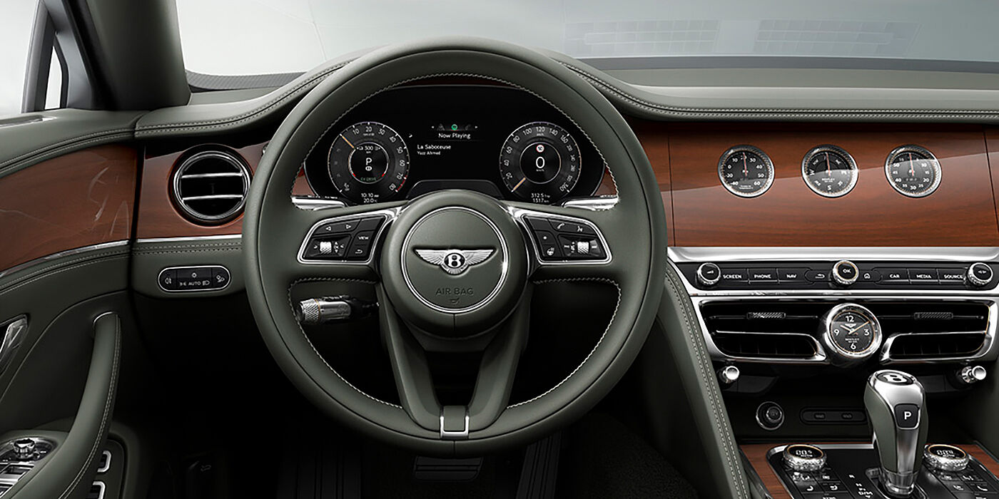 Bentley Tel Aviv New Bentley Flying Spur sedan front cabin in Cumbrian Green hide and Crown Cut walnut veneer showing steering wheel and Rotating Display with three clocks on face