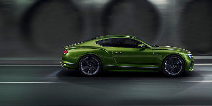  Bentley Tel Aviv Bentley Continental GT coupe in Tourmaline Green paint driving in profile on a dark road